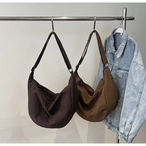 Detalle de bolsos hobo a cuadros marrones y beige con tejido texturizado y correas anchas
