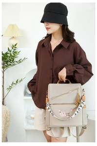 Détail de la broderie florale et du zip doré sur le sac à dos oxford beige