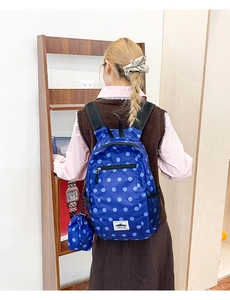 Detail view of blue polka dot backpack with side mesh pocket and matching mini pouch