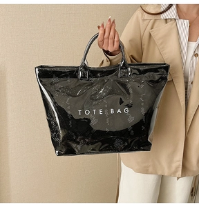 Detail of glossy snake pattern leather tote bag featuring white TOTE BAG lettering