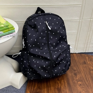 Detailed macro view of black canvas backpack featuring white stars and musical note patterns