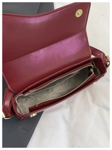 Interior view of the red leather handbag showing the spacious main compartment and zipper pocket