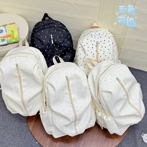 Detail showing five different star pattern school backpacks in white and black colors