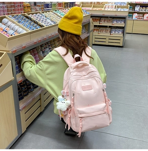 Detailed pink backpack featuring bow embroidery and a cute white bunny plush accessory