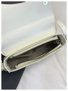 Top view of white leather shoulder bag showing internal compartments and gold hardware