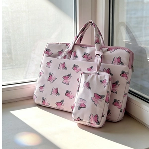 Detail view of a pink velvet laptop bag with butterfly prints in natural window light
