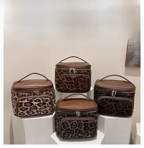 Display of leopard print cosmetic bags in four shades on minimalist pedestals