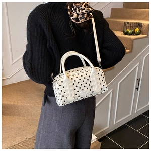 Detailed view of the white polka dot Boston bag worn cross-body with adjustable strap