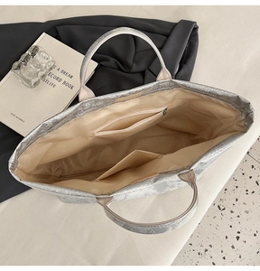 Interior view showing beige lining, zipper pocket, and snake pattern on tote bag