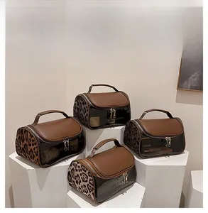 Detail view of leopard print toiletry bags with double zippers and top handles