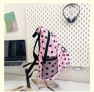 Pink polka dot backpack detail showing side mesh pocket and matching drawstring bag