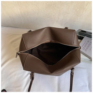Vue intérieure d'un grand sac cabas en cuir marron foncé avec ordinateur et livres