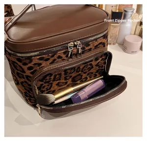 Close-up of leopard print makeup bag with top handle and front zipper pocket for brushes