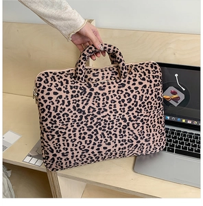 Detail of leopard print tote bag with reinforced handles and secure zipper closure