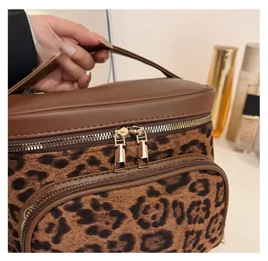 Close-up of leopard print makeup bag with gold zippers and sturdy brown handle