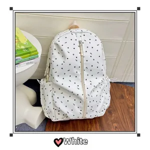 Detail of white nylon backpack featuring black star and music note print with front zipper