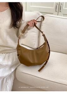 Detail of caramel brown leather hobo bag with pleated texture and adjustable strap