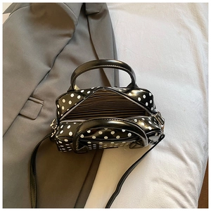 Top view of polka dot Boston bag showing striped lining and adjustable shoulder strap