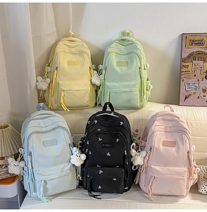 Detail view of colorful canvas backpacks with cute cloud pendants in five assorted soft colors