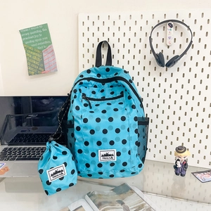 Close-up of blue polka dot backpack showing waterproof fabric texture and front pocket