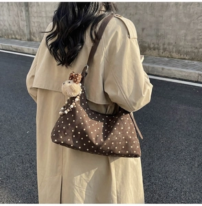 Detail of coffee polka dot shoulder bag in faux suede with plush puppy charm