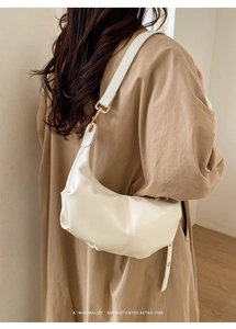 Detail showing soft cream hobo bag with retro texture and gold buckle on shoulder strap