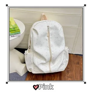 Close-up of white backpack with pink star patterns and side pockets in a lifestyle setting
