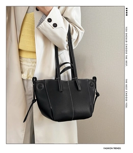 Detail of black tote bag featuring white contrast stitching and adjustable drawstrings