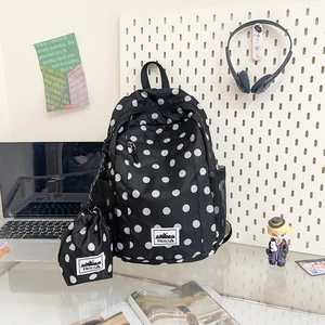 Polka dot backpack set with matching drawstring pouch shown in a stylish desk setup
