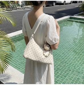 Detail of cream polka dot crossbody bag with cute plush bear pendant and beaded chain