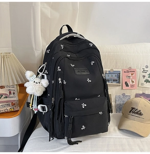 Detail of black backpack with white bow embroidery and white rabbit plush charm