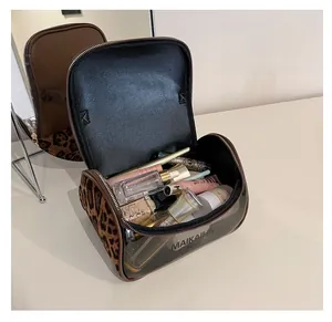 Detail view of double-layer leopard print makeup bag with transparent PVC panel and top zipper