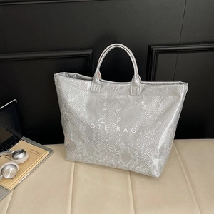 Grey snakeskin pattern tote bag with TOTE BAG print and double handles in a modern setup