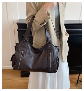 Close-up of vintage dark brown tote bag showing smooth leather texture and side pockets