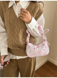 Close-up of floral canvas shoulder bag with pink roses, pleat texture and ribbon bow detail