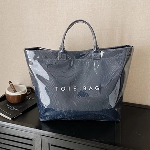 Glossy snake-embossed dark blue tote bag with white lettering and sturdy top handles