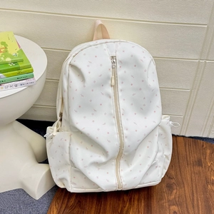 Detail view of the star and music note patterns on a white school backpack with side pockets