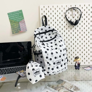 Detail of white polka dot backpack with matching drawstring bag and side mesh pocket