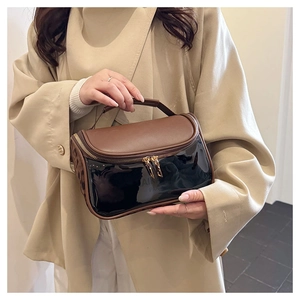 Double-layer travel makeup bag with brown leather top and translucent black lower section
