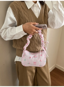 Close-up of pink floral seersucker shoulder bag featuring 3D textures and bow details