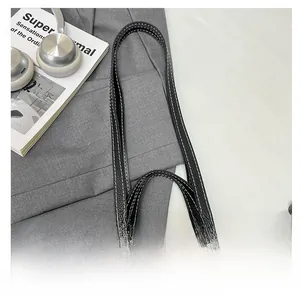 Detail of black lychee grain tote bag with white contrast stitching and long shoulder straps