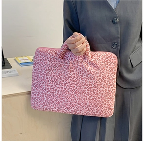 Pink leopard print laptop bag held by a model in a professional office setting