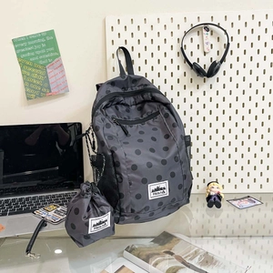Polka dot backpack set with drawstring pouch on a desk with a laptop and accessories