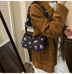 Detail of floral canvas bag with pink bow prints and textured fabric on shoulder