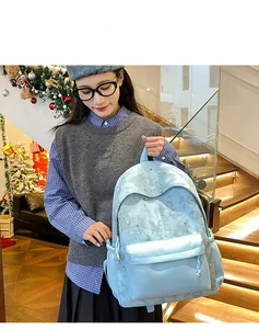 Detail view of light blue starry backpack featuring a front pocket and side drawstring details