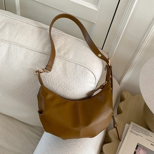 Caramel faux leather crescent shoulder bag with adjustable strap and gold metal accents
