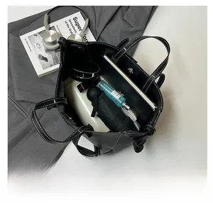 Top view of spacious black lychee pattern tote bag with daily commuter essentials inside