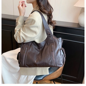 Detail view of vintage dark brown tote bag showing textured faux leather and zip decoration