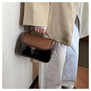 Close-up of double-layer travel toiletry bag with brown and black glossy faux leather