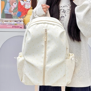 Detail of cream student backpack with star prints and vertical zipper in casual setting